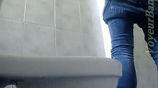 Sexy lean white chick in tight jeans pissing in the toilet