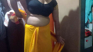 Indian housewife is wearing a yellow saree.